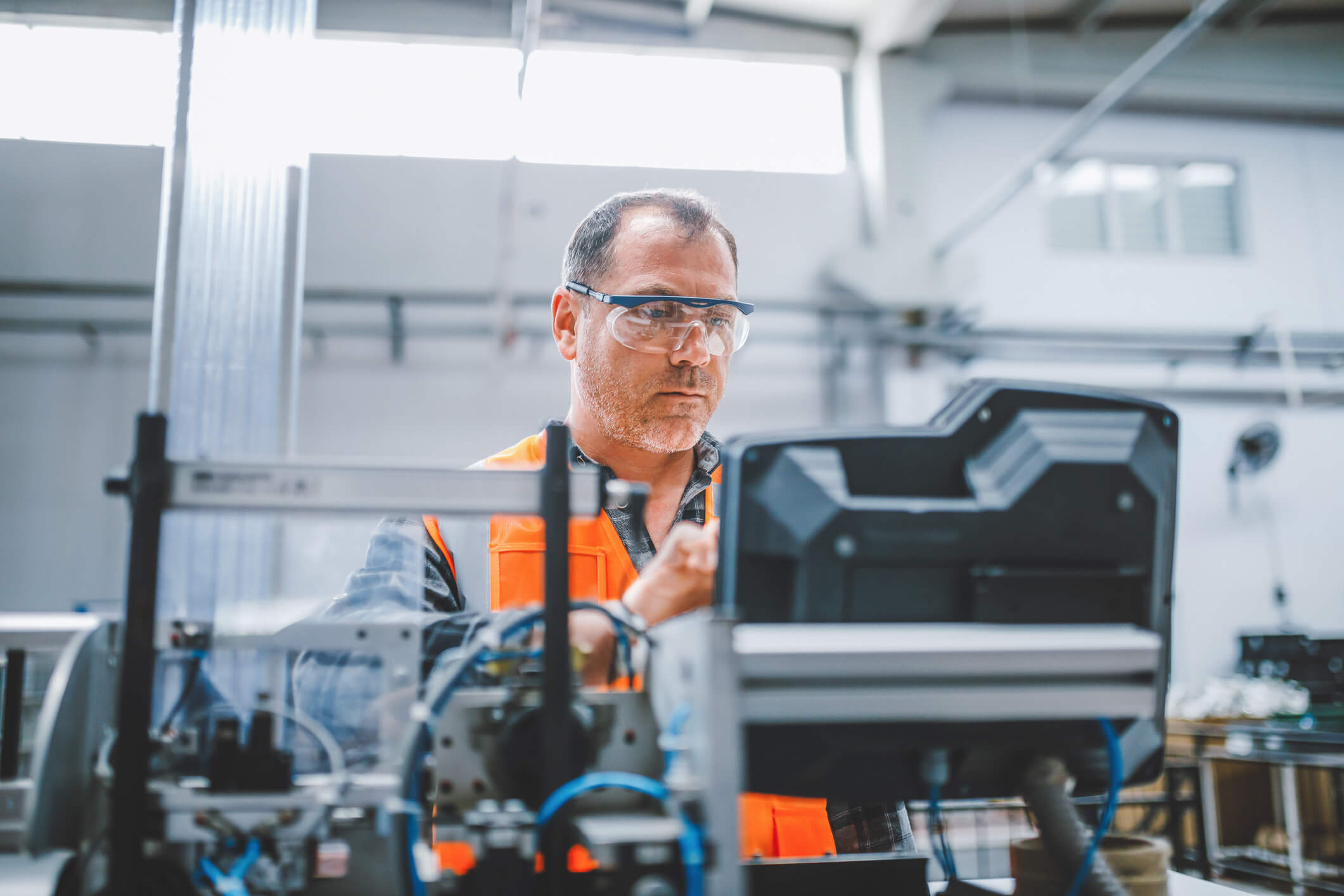Professional industrial factory man employee working with machine parts putting, checking and testing industrial equipments cables in large Electric electronics wire and cable manufacturing plant factory warehouse