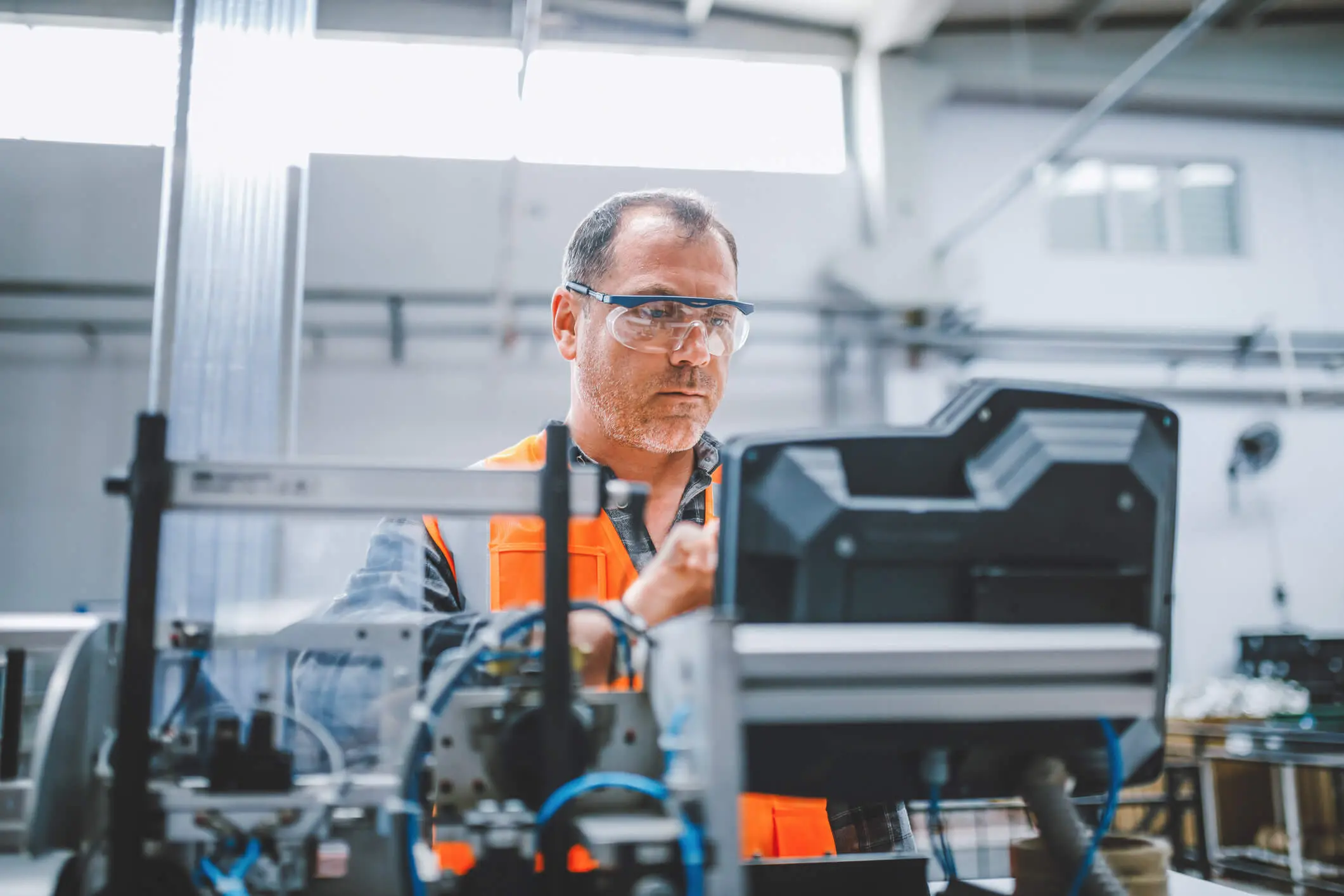 Professional industrial factory man employee working with machine parts putting, checking and testing industrial equipments cables in large Electric electronics wire and cable manufacturing plant factory warehouse